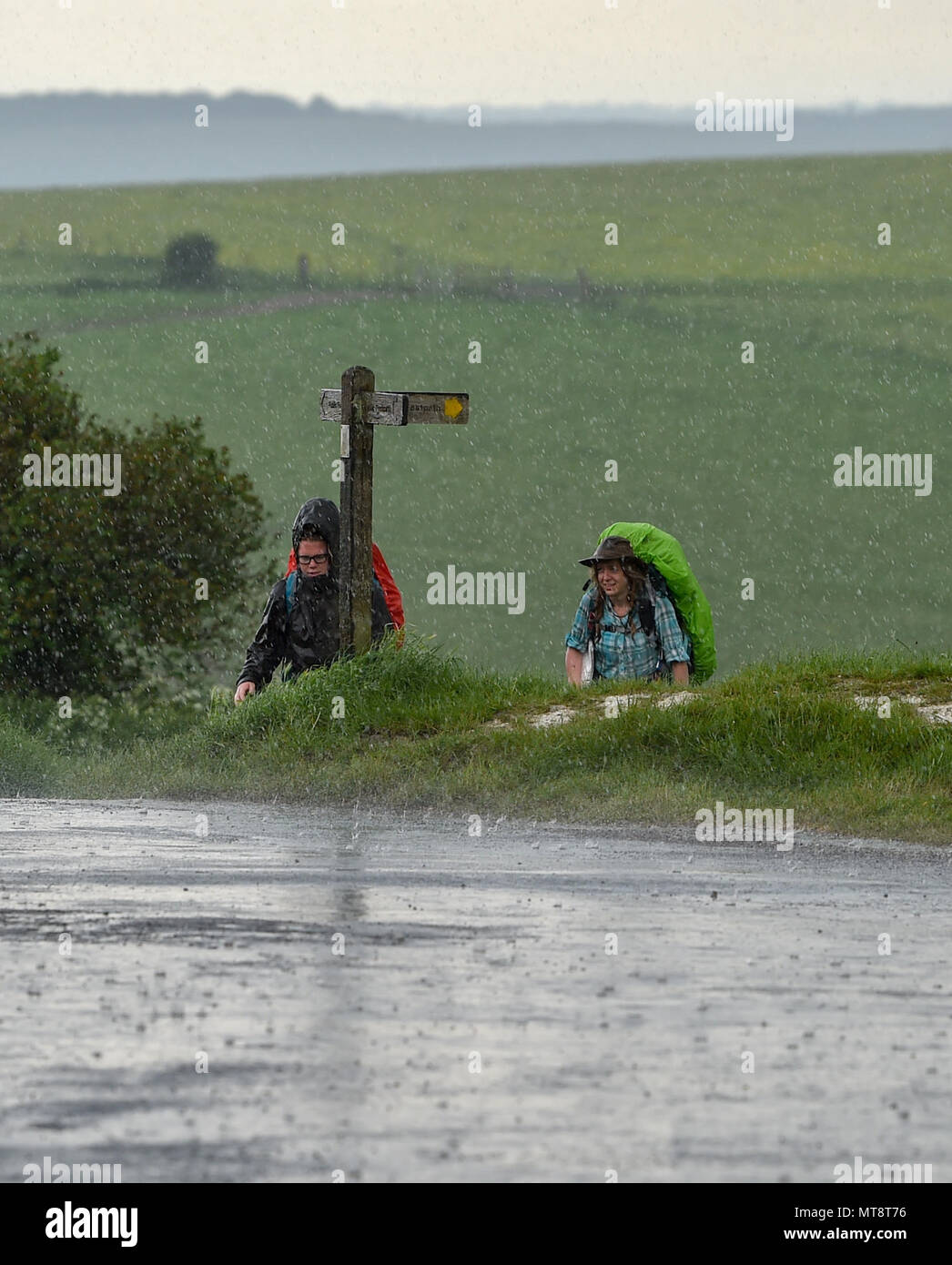 Brighton Regno Unito 28 maggio 2018 - Walkers impigliarsi in una tempesta di pioggia pesante come si passa sopra il ben noto spot di bellezza di diavoli Dyke sulla South Downs appena a nord di Brighton durante la vacanza della banca di credito di oggi: Simon Dack/Alamy Live News Foto Stock