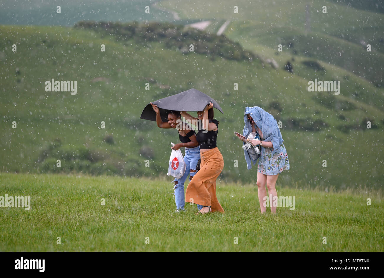 Brighton Regno Unito 28 maggio 2018 - I visitatori hanno per rendere dash per esso come una tempesta con heavy rain passa sopra il ben noto spot di bellezza di diavoli Dyke sulla South Downs appena a nord di Brighton durante la vacanza della banca di credito di oggi: Simon Dack/Alamy Live News Foto Stock