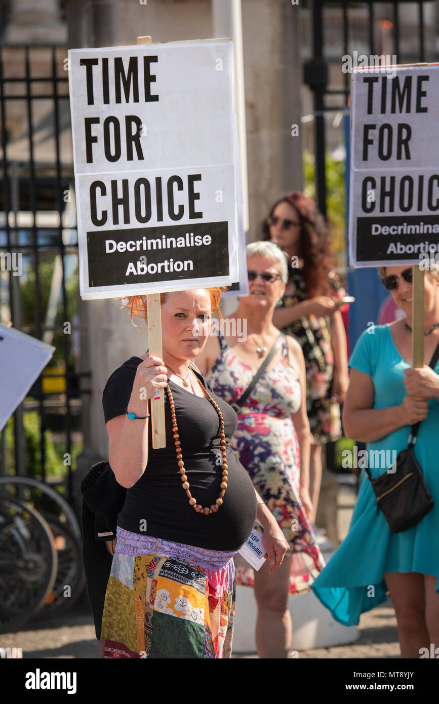 Belfast, Irlanda del Nord. 28/05/2018 - una donna incinta detiene una targhetta dicendo "Tempo per la scelta. Depenalizzare l'aborto". Circa 500 persone si radunano a Belfast City Hall di chiamare per la depenalizzazione dell aborto in Irlanda del Nord. Si tratta del giorno dopo un referendum svoltosi nella Repubblica di Irlanda ha restituito un sostanziale sì alla rimozione del ottavo emendamento della costituzione che dà uguale diritto di vita sia per la madre che per il bambino, efficacemente il divieto di aborto in tutte le circostanze. Foto Stock