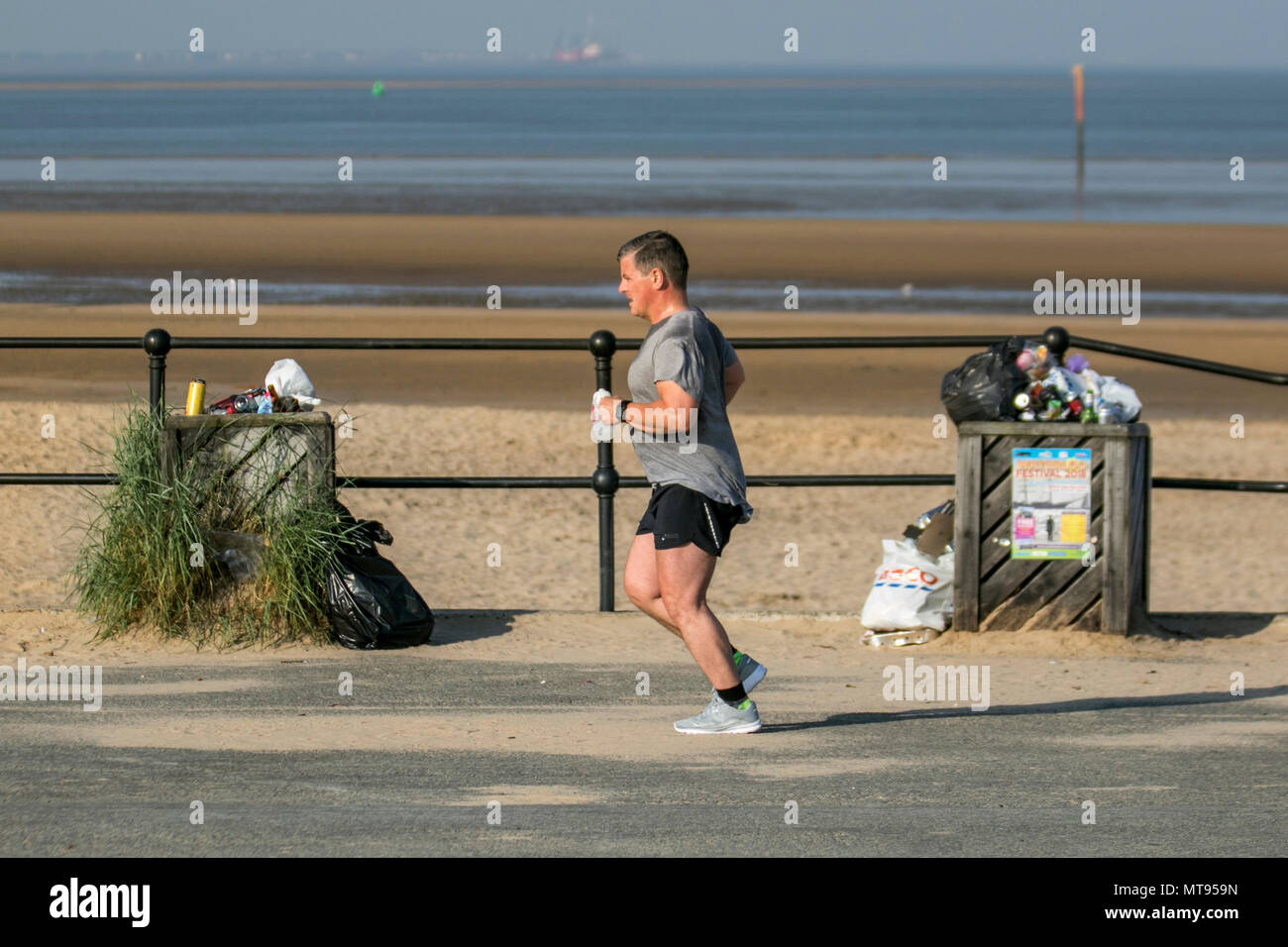 Crosby, Liverpool. 29 Maggio, 2018. Meteo REGNO UNITO: luminosa giornata estiva sulla costa nord-ovest come residenti locali e turisti prendere l'esercizio del mattino sul sentiero costiero e Merseyside beach. La spiaggia è addobba con Spring Bank Holiday lettiera con traboccante raccoglitori di immondizia e soffiare nella brezza. Il Consiglio Sefton contenitori chiaramente insufficienti per la quantità di rifiuti in plastica. Credito: MediaWorldImages/AlamyyLiveNews. Foto Stock