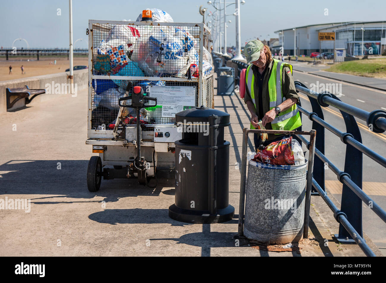 Southport, Merseyside, 29 maggio, 2018. Meteo REGNO UNITO: luminosa giornata estiva sulla costa nord-ovest come residenti locali e turisti prendere l'esercizio del mattino sul sentiero costiero e Merseyside beach. La spiaggia è addobba con Spring Bank Holiday lettiera con traboccante raccoglitori di immondizia e soffiare nella brezza. Foto Stock
