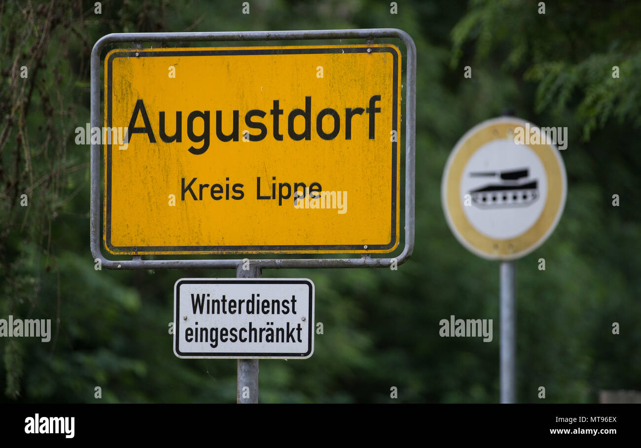 29 maggio 2018, Germania, Augustdorf: un segno a leggere 'Augustdorf'. Dietro di esso è un segno con un serbatoio. A causa della rotazione prevista di noi le forze militari in Europa orientale, noi veicoli militari sono la guida su autostrada federale A2, con una sosta presso la baracca militare dell'esercito tedesco (Generalfeldmarschall-Rommel-Kaserne). L'operazione 'Atlantic risolvere" con circa 300 veicoli è di essere completato entro la fine del mese. I trasporti militari potrebbero causare interruzioni temporanee del traffico. Foto: Friso Gentsch/dpa Foto Stock