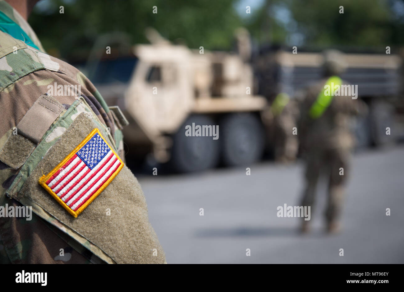 29 maggio 2018, Germania, Augustdorf: un soldato americano, con il 'stelle e strisce' cucita sul manicotto della sua uniforme, in piedi nella parte anteriore di un veicolo militare. A causa della rotazione prevista di noi le forze militari in Europa orientale, noi veicoli militari sono la guida su autostrada federale A2, con una sosta presso la baracca militare dell'esercito tedesco (Generalfeldmarschall-Rommel-Kaserne). L'operazione 'Atlantic risolvere" con circa 300 veicoli è di essere completato entro la fine del mese. I trasporti militari potrebbero causare interruzioni temporanee del traffico. Foto: Friso Gentsch/dpa Foto Stock