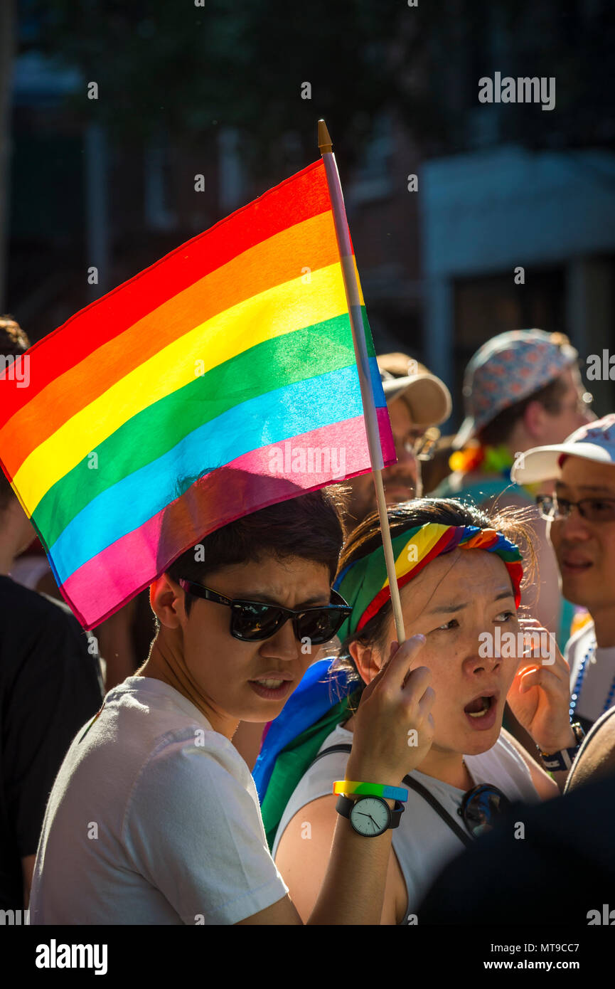 NEW YORK CITY - Giugno 25, 2017: amici asiatici wave arcobaleno e noi le bandiere sugli spalti dell annuale Pride Parade in Greenwich Village Foto Stock