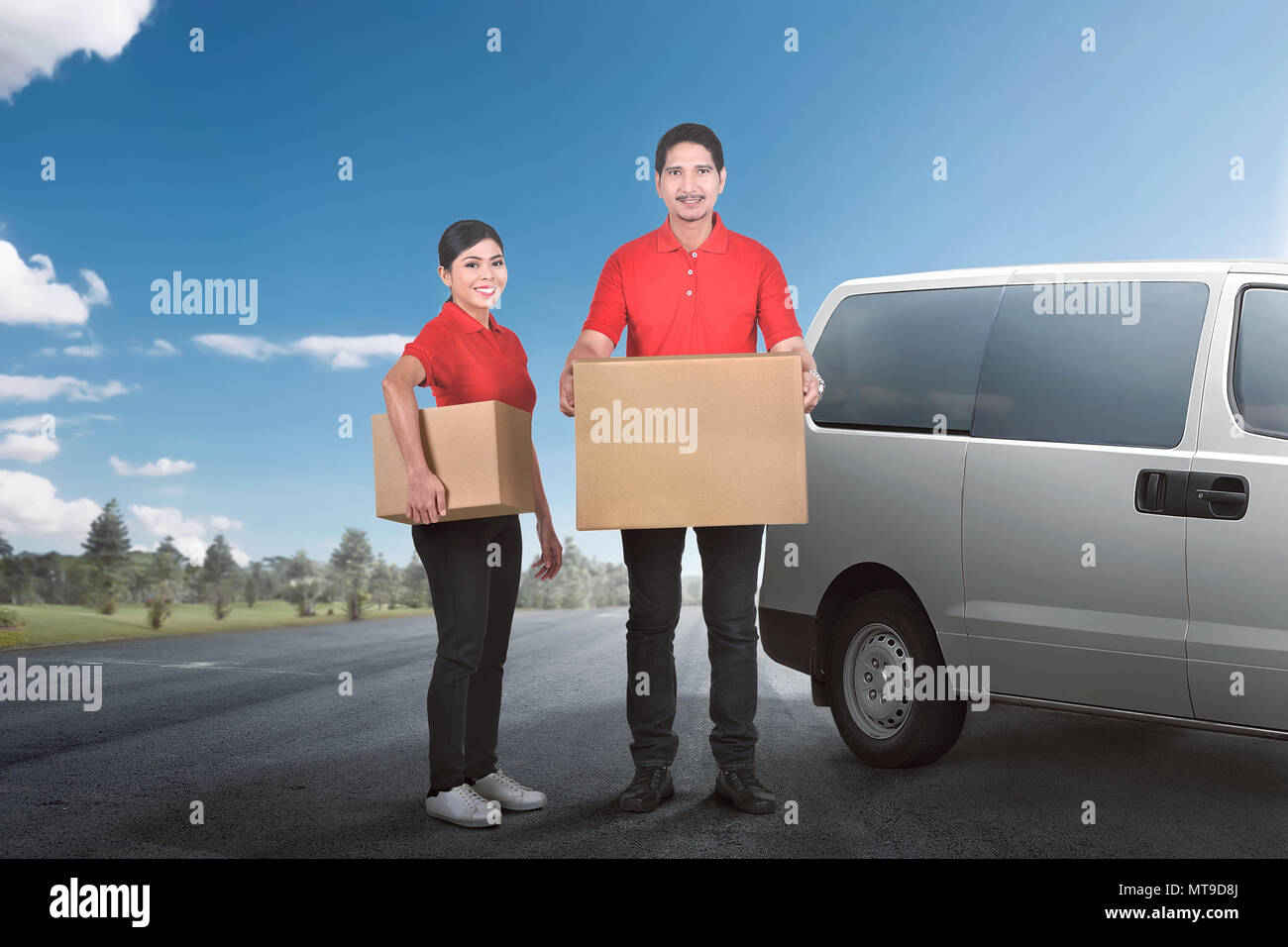 Felice corriere asiatico team a fornire il pacchetto per le persone con van sullo sfondo Foto Stock
