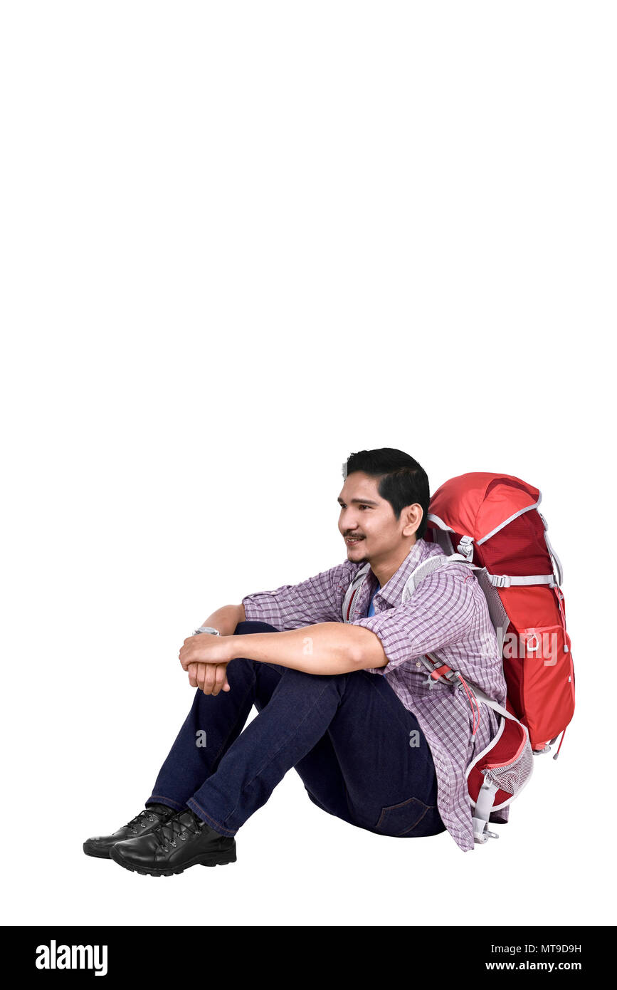 Ritratto di asiatici uomo di viaggiatori con zaino seduta isolate su sfondo bianco Foto Stock
