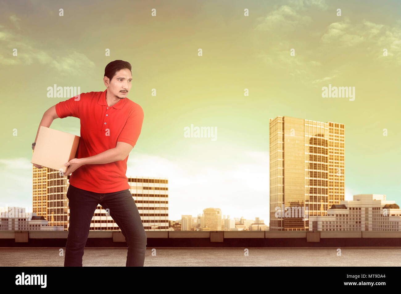 Bella asiatica uomo lavoratore consegnare il pacco al ricevitore sulla città Foto Stock