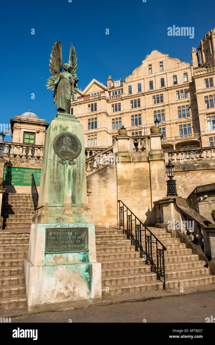 La statua di Angelo della pace in memoria di Edward VII noto come pacificatore in Parade Gardens e Empire Hotel in background, bagno, Somerset, Regno Unito Foto Stock