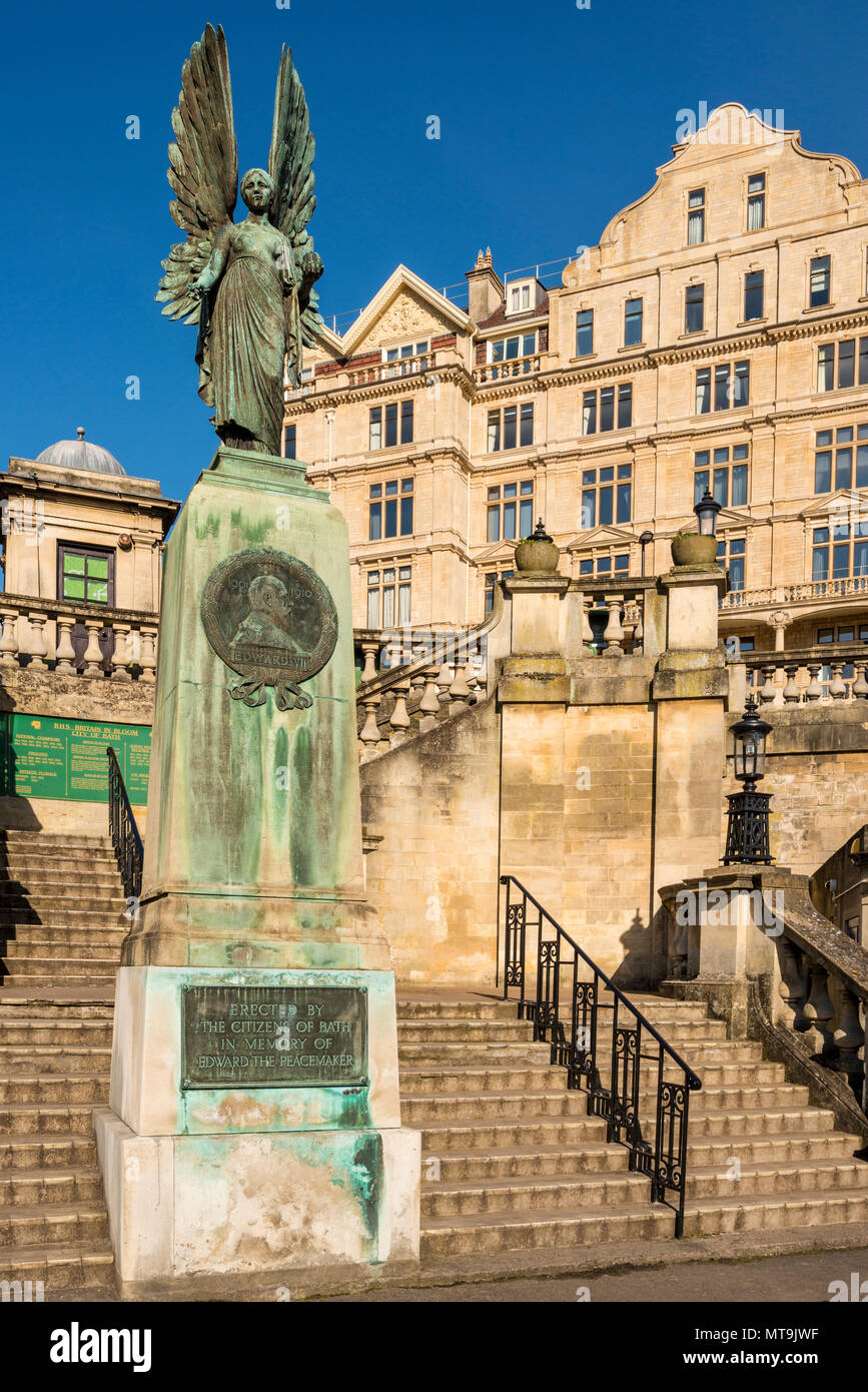 La statua di Angelo della pace in memoria di Edward VII noto come pacificatore in Parade Gardens e Empire Hotel in background, bagno, Somerset, Regno Unito Foto Stock