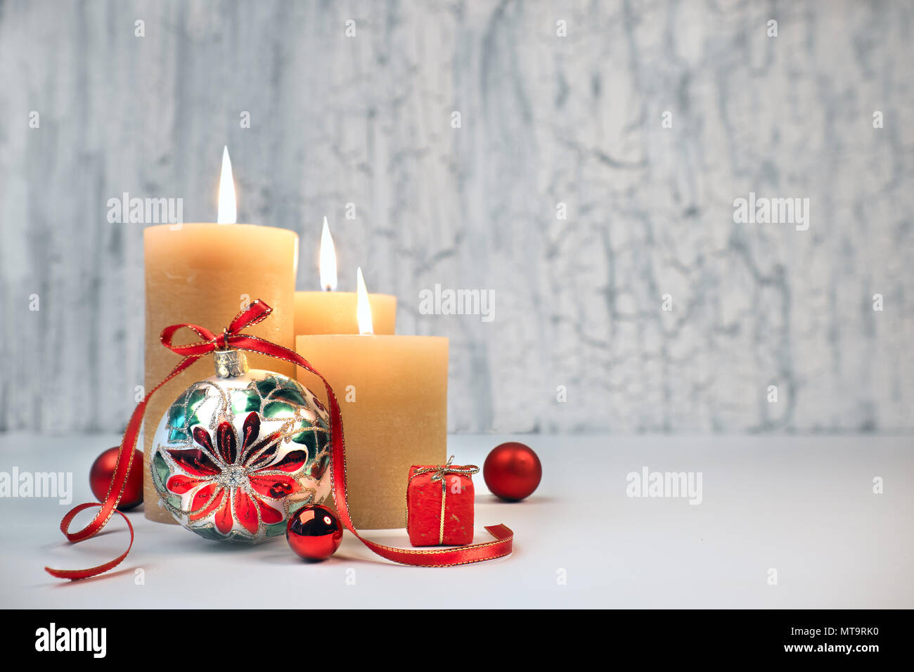 Tre candele accese con golden Natale decorazioni rustico sfondo neutro. Buon terzo Avvento! Questa immagine è tonica e ha spazio per il t Foto Stock
