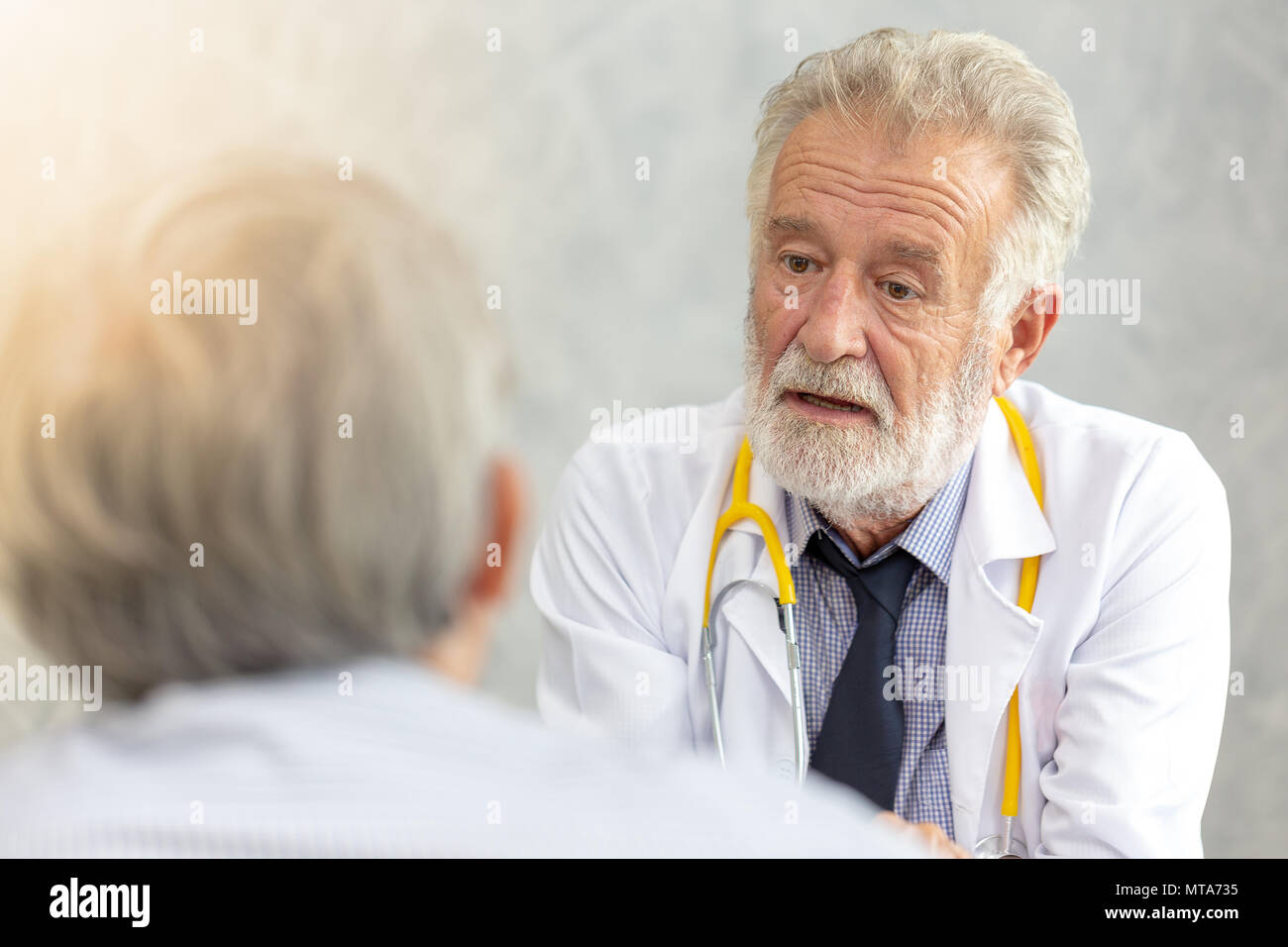 Senior di medico o di medico capo dando una consultazione per il suo paziente di sesso maschile e spiegando le informazioni mediche e diagnosi presso la clinica o hos Foto Stock