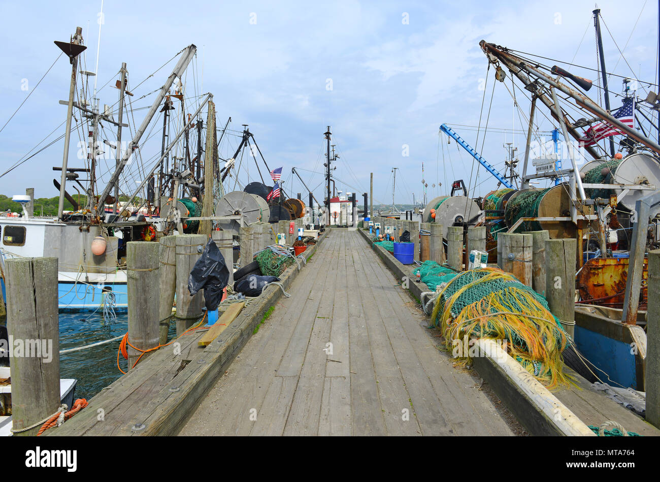 Scena marittima con commerciale barche da pesca in acqua vicino al dock Foto Stock