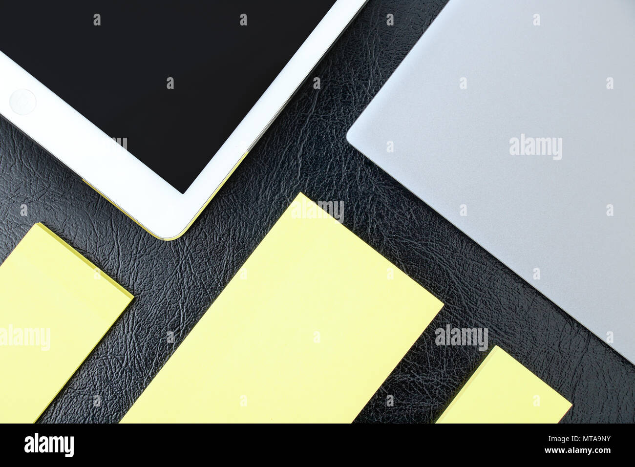 Sovraccarico di office la tabella con i notebook, tablet pc e blocco note giallo spazi di copia Foto Stock