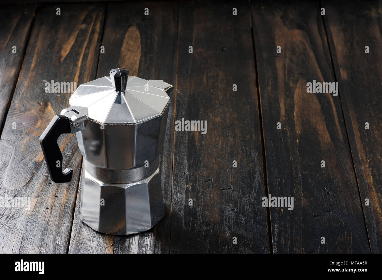 Stile italiano caffettiera moka o pentola isolato su sfondo di legno Foto Stock