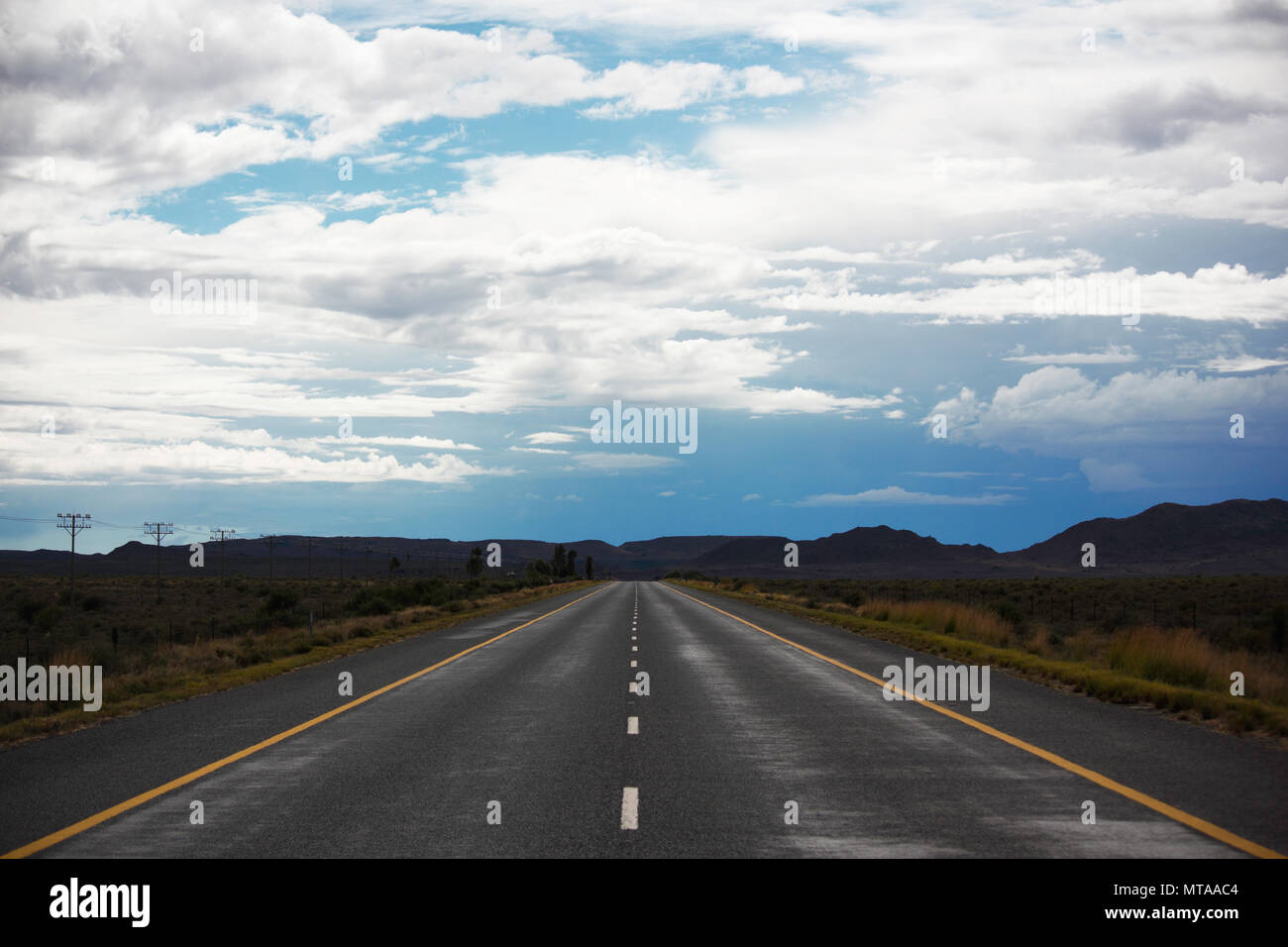Strada asfaltata dritto verso la distanza Foto Stock