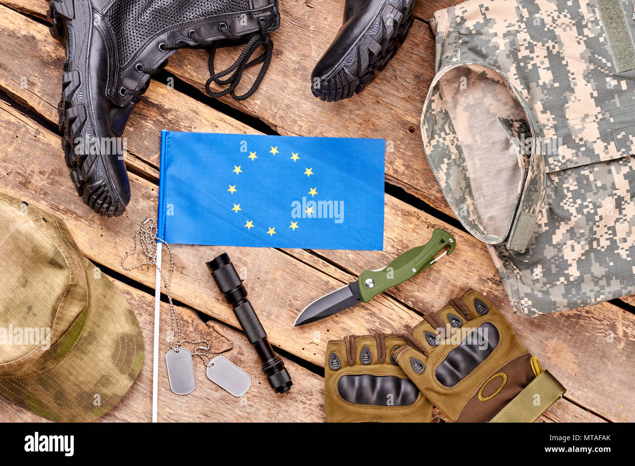 Esercito europeo soldato disposizione degli elementi. Appartamento laico, vista dall'alto. Concetti di base militare su legno. Foto Stock