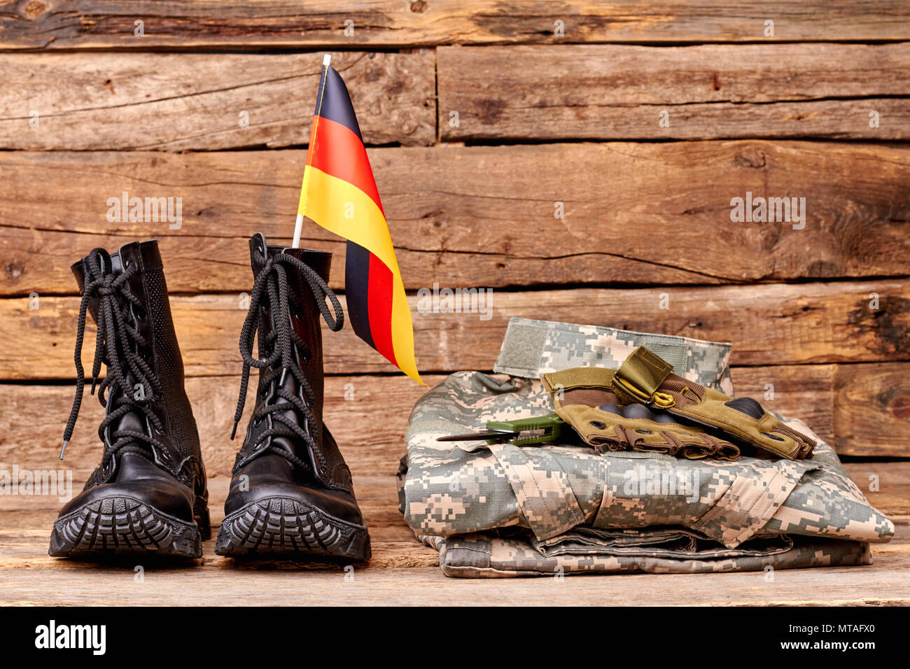 Set di abbigliamento militare di deutsch soldato. Bandiera della Germania  in stivali neri su uno sfondo di legno Foto stock - Alamy