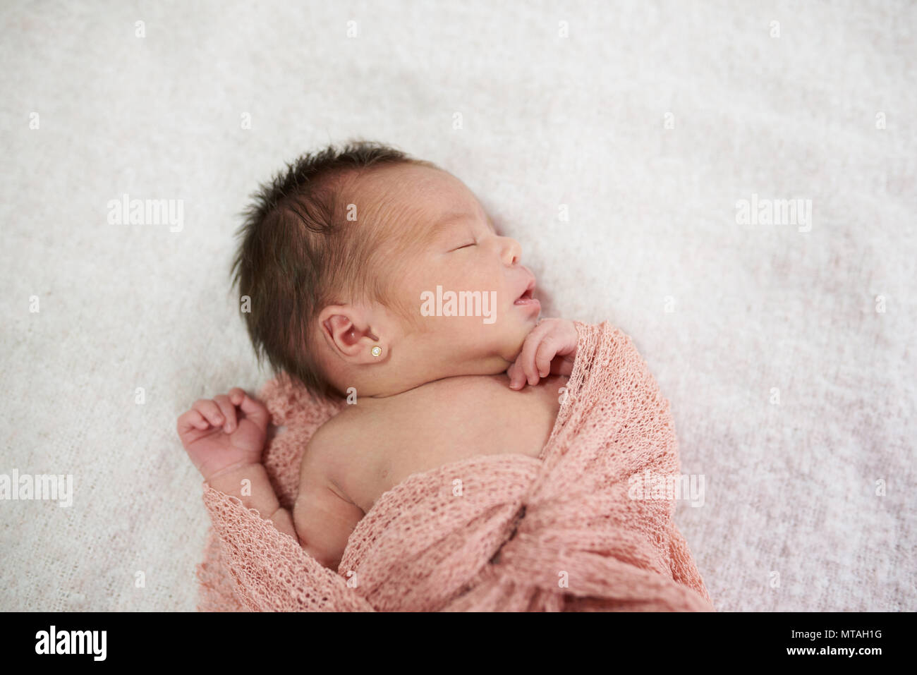 Il Neonato che dorme sul morbido manto luminose in background Foto Stock