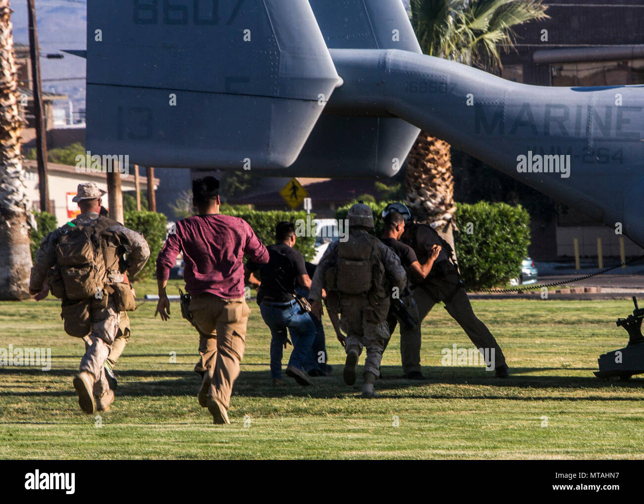 Stati Uniti Marines con Golf Company, 2° Battaglione, 6° Reggimento Marine, e un U.S. Marine Corps capo equipaggio con Marines Aviation di armi e tattiche di uno squadrone (MAWTS-1) Ruolo di arresto i giocatori dal bordo di un MV-22B Osprey durante l assalto tattiche di supporto 3 (AST-3) come parte di armi e tattiche corso istruttori (WTI) 2-17 a venti nove palmi, California, 21 aprile 2017. AST-3 è un esercizio incentrato sulla conduzione noncombatant operazione di evacuazione (NEO) in un ambiente urbano mentre simultaneamente straniere che forniscono assistenza umanitaria (FHA) per la simulazione di nazione ospitante. WTI è di sette settimane di allenamento anche Foto Stock