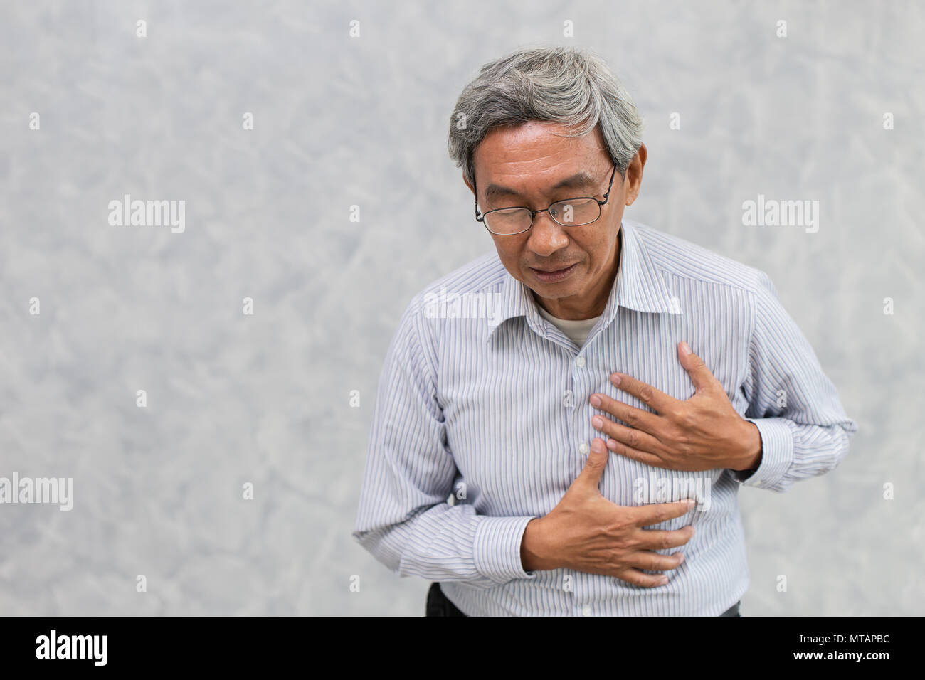 Anziano asiatico soffrono di dolore al petto da un attacco di cuore o di corsa con spazio per il testo. Foto Stock