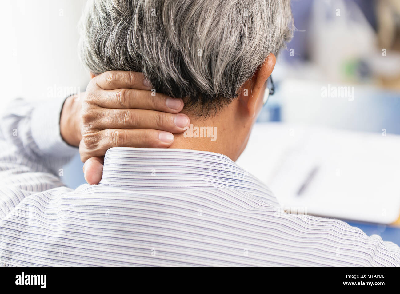 Asian vecchio uomo schiena dolore al collo con la mano per massaggio e strofinare il coperchio a mano. Foto Stock