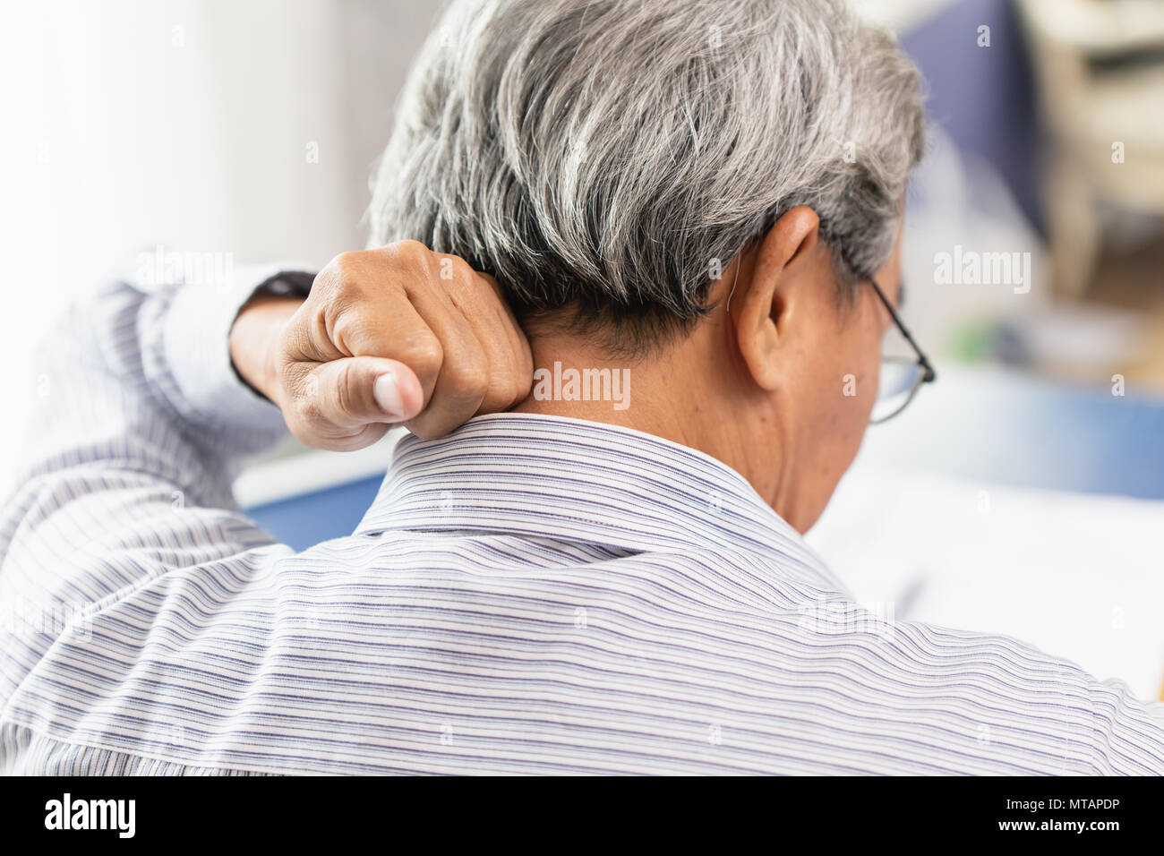 Asian Elder schiena dolore al collo con la mano per massaggio e rub. Foto Stock