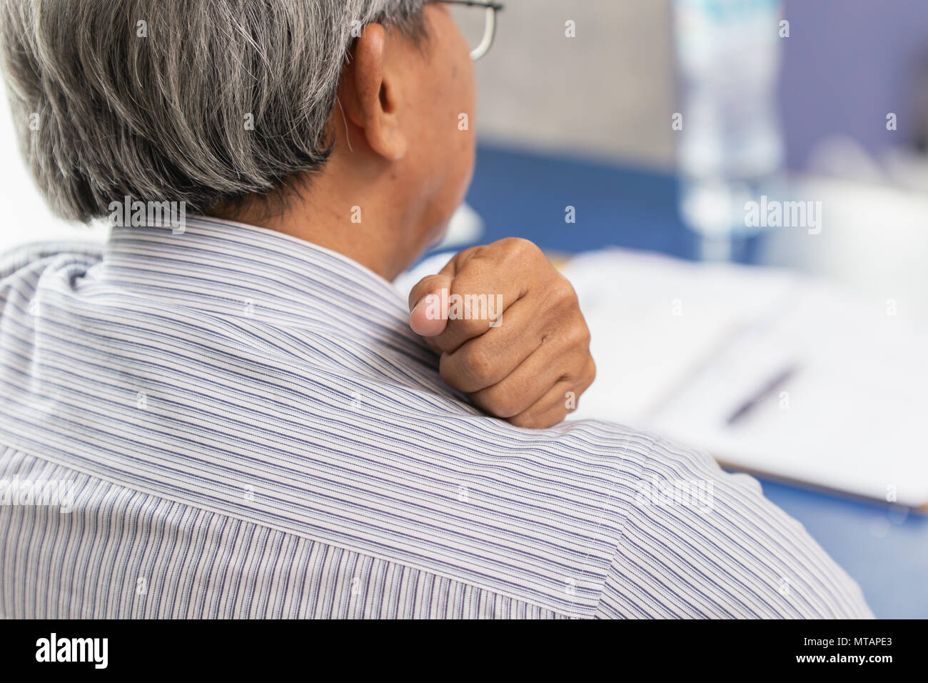 Asian anziani indietro il collo e il dolore alla spalla con la mano per massaggio e rub. Foto Stock