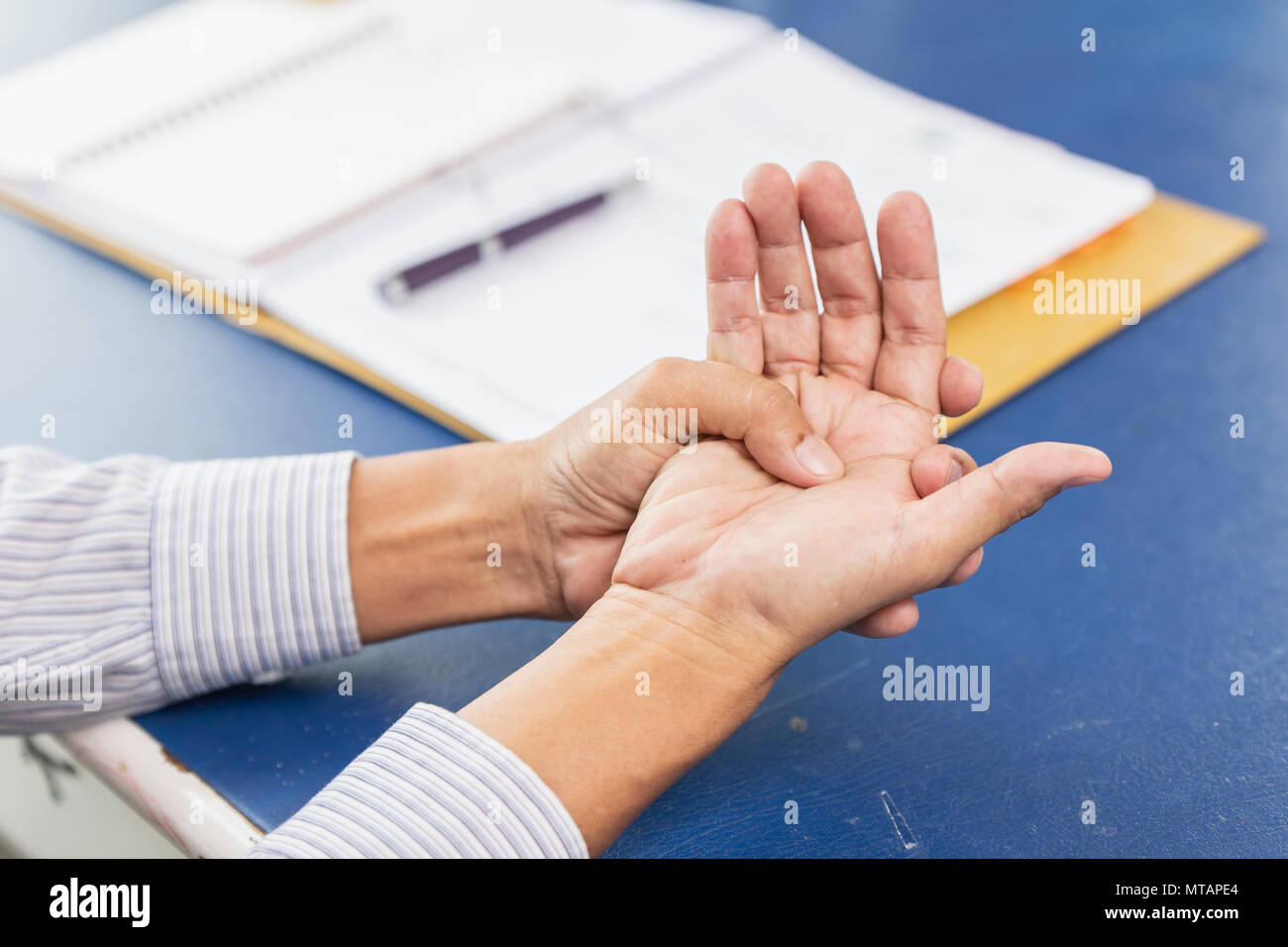 Closeup old man mano palm tendine comune dolore muscolare dopo la scrittura di duro lavoro in ufficio Foto Stock