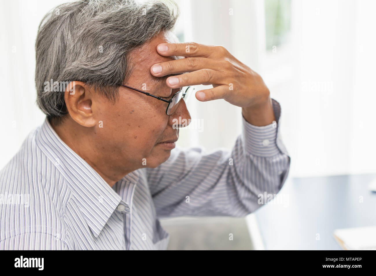Asian elder mal di testa dolore soffrono di stress in vista laterale. Foto Stock