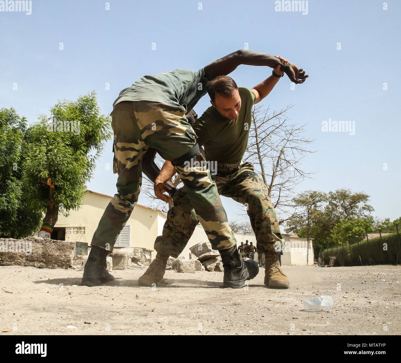 Marinaio JuanCarlos Mendez, un corpsman con scopi speciali Air-Ground Marine Task Force - Risposta in caso di crisi - Africa, si prepara a vigile del fuoco portano un membro del Senegal di Compagnie Fusilier de Marin Commando durante quattro settimane di esercizio a Toubakouta, Senegal, 21 aprile 2017. Marines con SPMAGTF-CR-AF e il COFUMACO condotta a quattro alla settimana di formazione professionale esercizio che includeva il combattimento avanzate tecniche di cottura, una mitragliatrice gamma e un live-fire attacco di plotone di gamma. Foto Stock