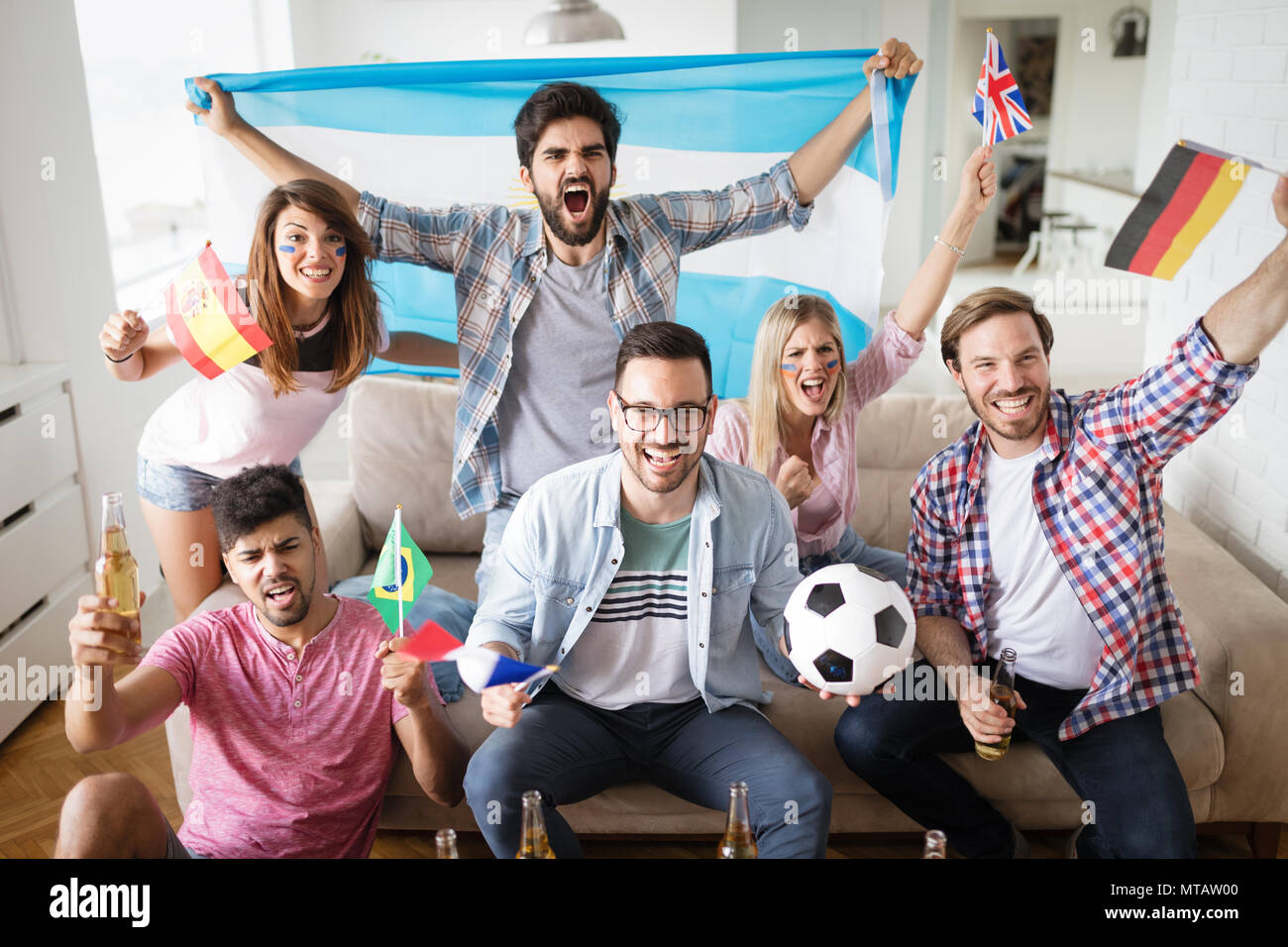 Allegro gruppo di amici guardare la partita di calcio in tv. Foto Stock