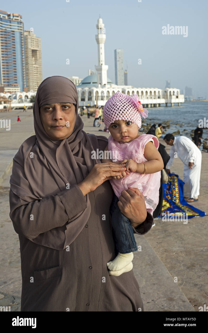 Nonna trattiene bambina tra le sue braccia durante il Ramadan di Jeddah, Arabia Saudita Foto Stock