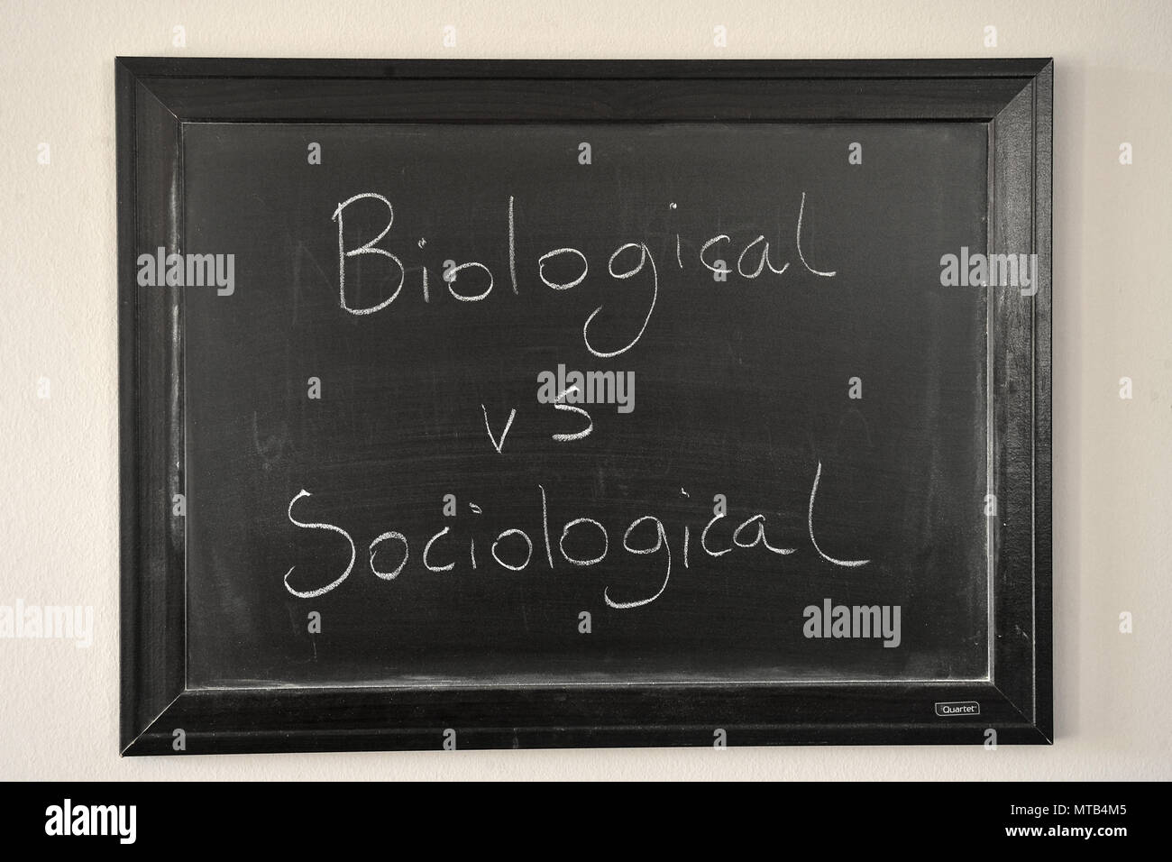 Vs biologici sociologico scritto in un bianco gesso su una parete montata blackboard Foto Stock