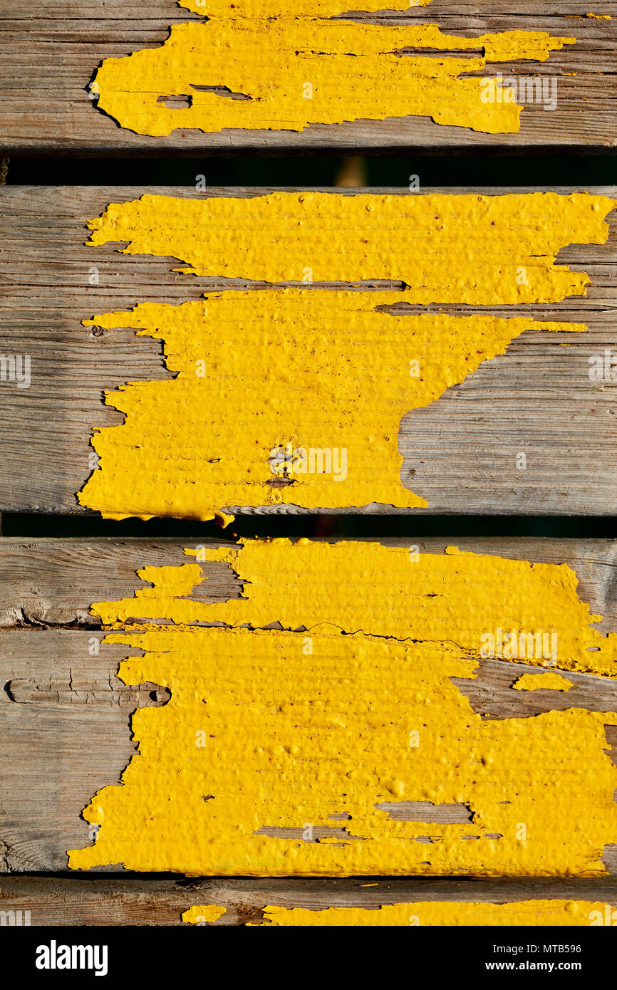 Tavole di legno usurata con vernice gialla di un porto. Vista superiore close up sfondo. Foto Stock