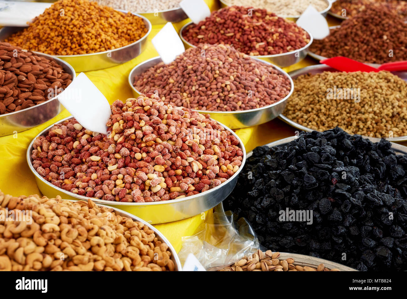 Pila di arachidi tostate, anacardi, secco prune, mais, mandorla e dado in metallo tonda vassoi in un autentico bazaar Foto Stock