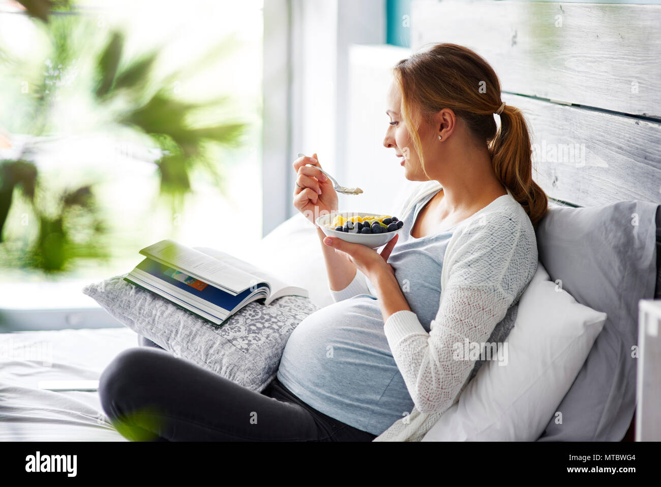 Donna incinta in un momento di relax a camera da letto Foto Stock