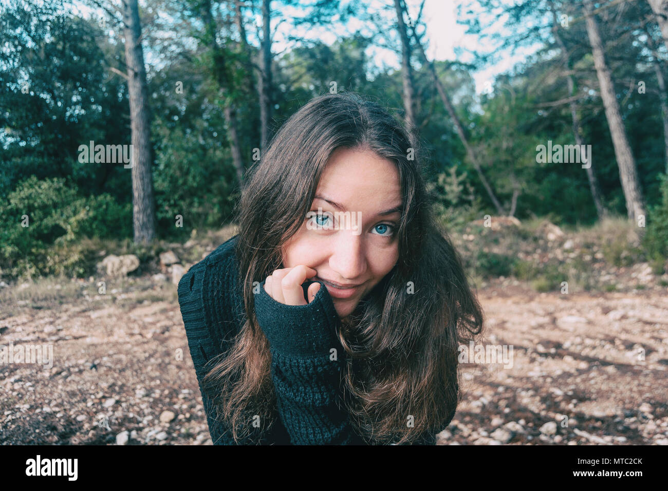 Una ragazza con i capelli lunghi e gli occhi blu in montagna sorridente Foto Stock