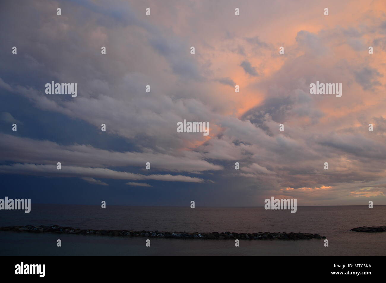 Tramonto sul mare Mediterraneo dal punto di vista dell'Italia, con cielo molto nuvoloso Foto Stock