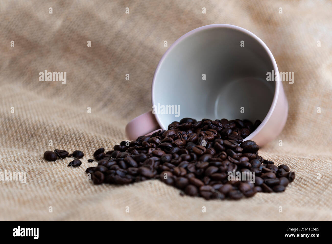 I chicchi di caffè e una tazza di rosa su sfondo arrugginito con spazio di copia Foto Stock