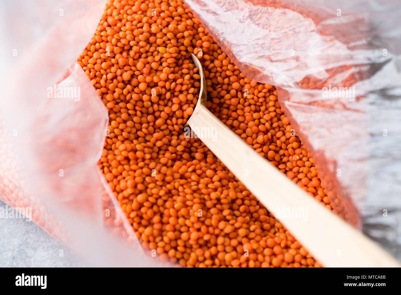 Rosso Secco lenticchie in cucchiaio di legno / Cereali Masoor Dal. Prodotto organico. Foto Stock