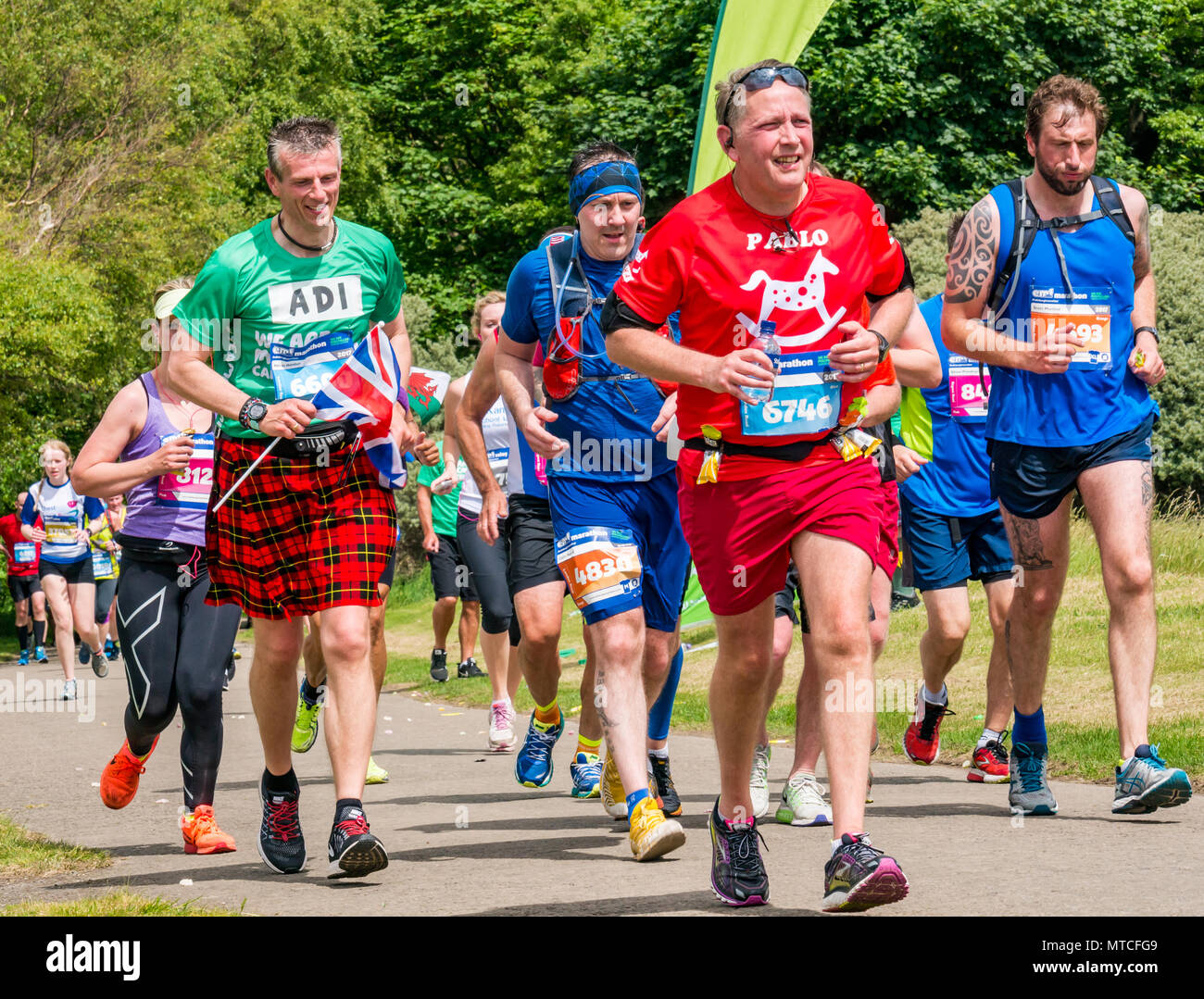 Gosford station wagon, East Lothian, Scozia, Regno Unito. Il 28 maggio 2017. Corridori della maratona nella maratona di Edimburgo a Mile 18 con uomo in kilt che trasportano Union Jack flag Foto Stock