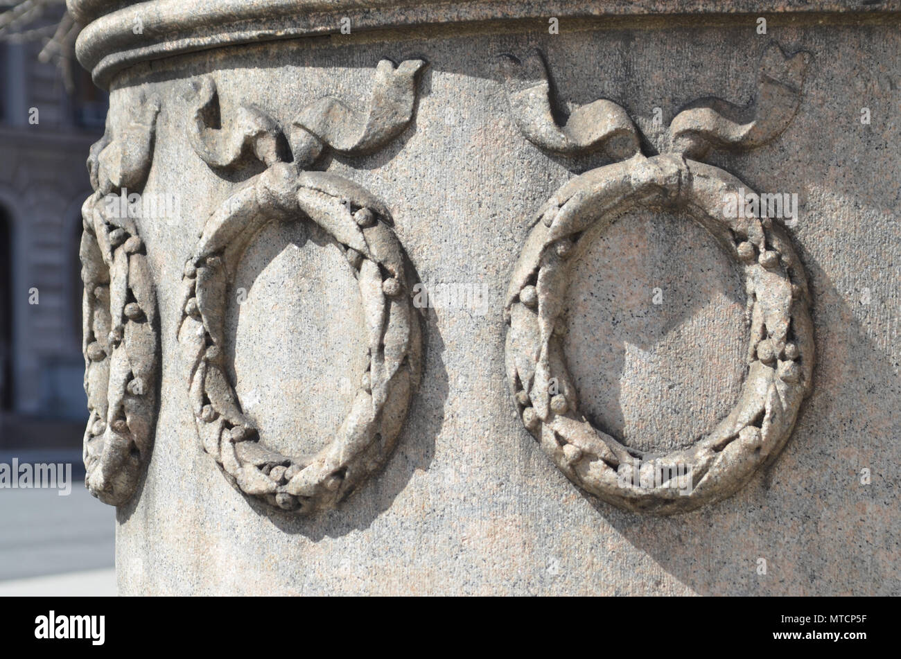 Primo piano di tre corone di fiori decorativi scolpiti in pietra su un edificio dal 1800s Foto Stock