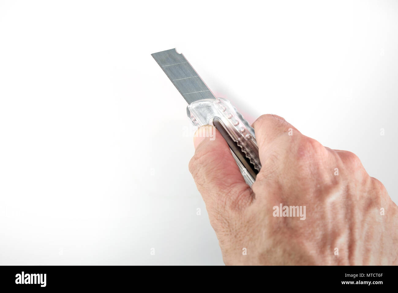 Carta coltello in mano su sfondo bianco. Foto Stock