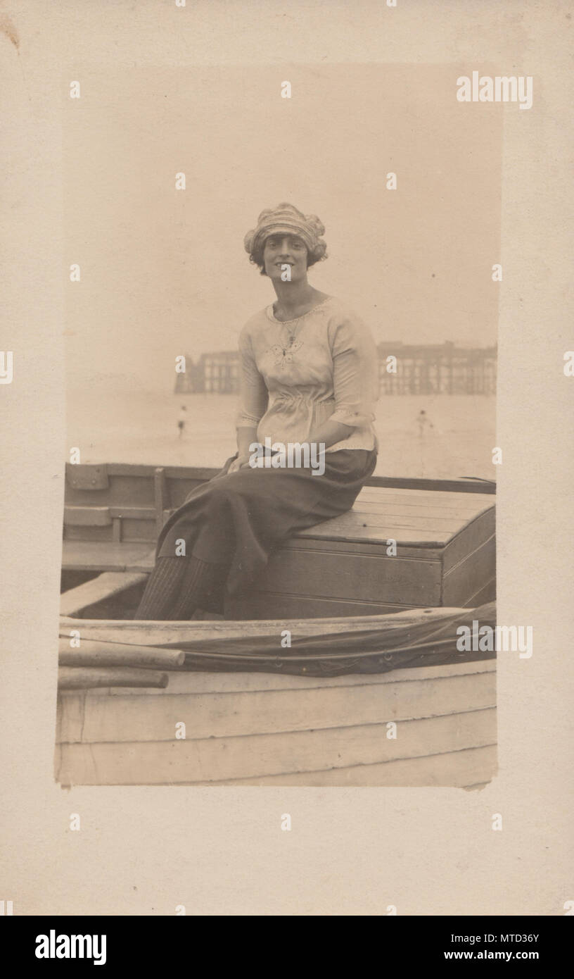 Vintage fotografia di un Edwardian Lady Sat in una barca a Hastings Beach, Sussex, Inghilterra Foto Stock