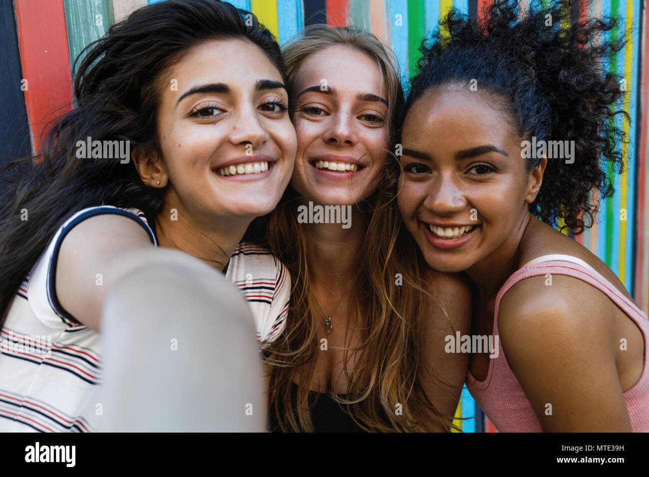 Happy amici prendendo un selfie. Tre donne sorridente guardando la fotocamera su un telefono cellulare. Foto Stock