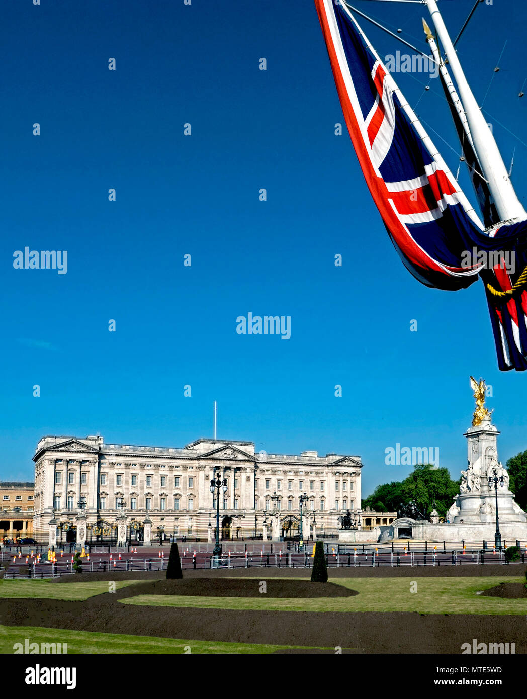 Vista di Buckingham Palace e il Queen Victoria Memorial da St James Park, inquadrata con la bandiera del Regno Unito Foto Stock