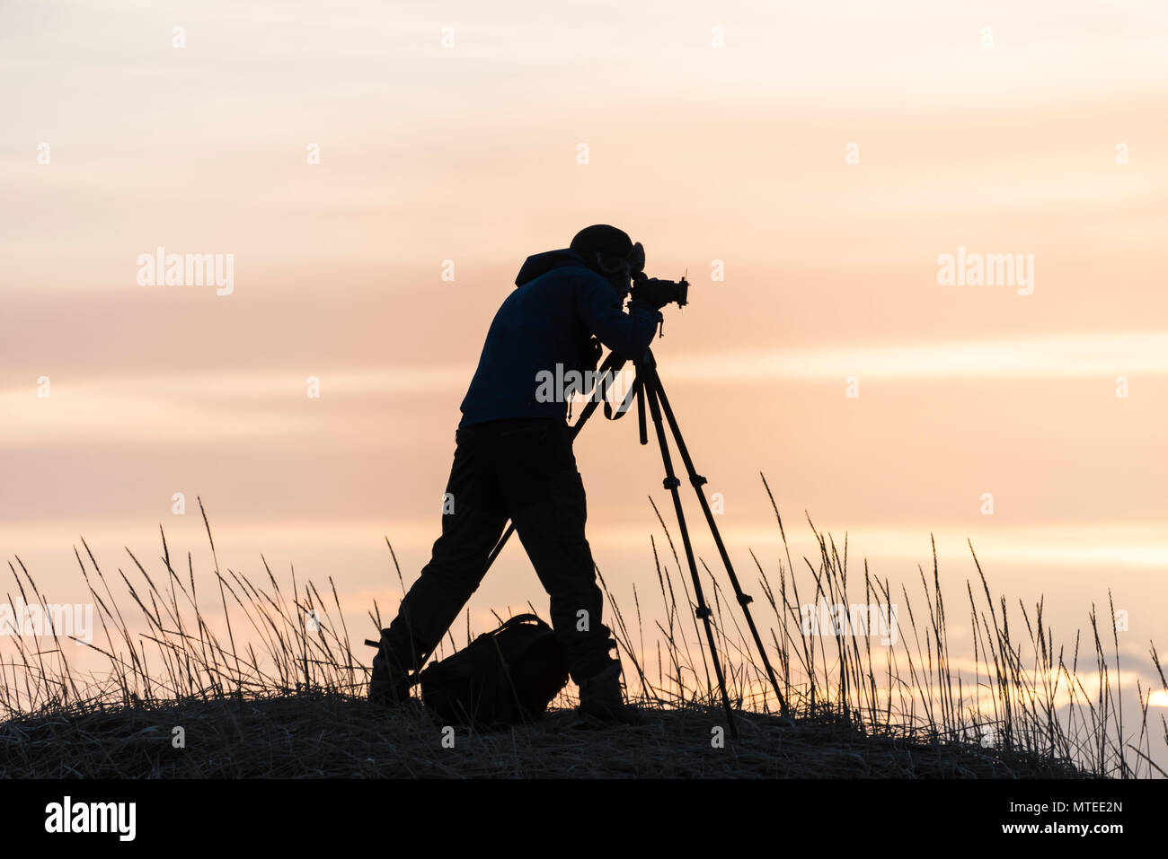 Silhouette di un fotografo con il cavalletto, tramonto, vicino Stokksnes, Islanda Foto Stock