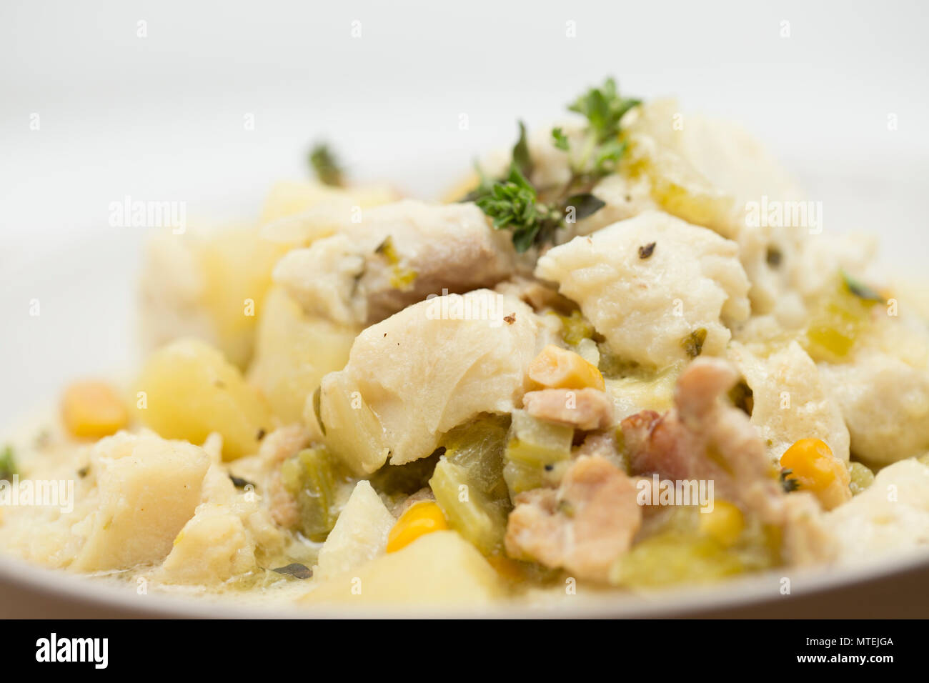 Una ciotola di zuppa fatta dal Pollack, Pollachius pollachius, tagliata a cubetti di pancetta affumicata, le patate, il sedano, il granturco dolce, la cipolla, la panna, il brodo di pesce e flav Foto Stock