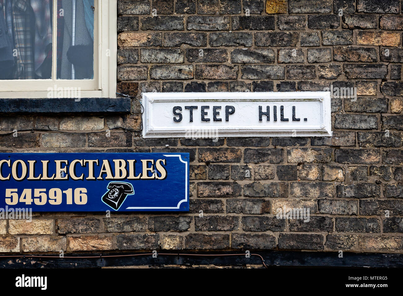 Medievale collina ripida strada segno su un muro di mattoni a Lincoln, East Midlands, Regno Unito prese il 23 maggio 2018 Foto Stock
