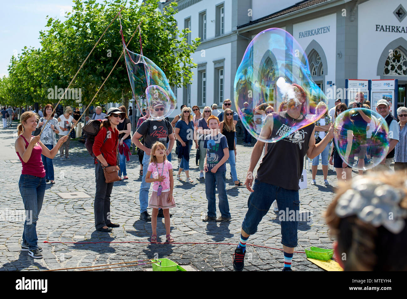 Coppia di animatori divertente i bambini e pubblico a soffiare bolle (e) del fumo sulla piazza di Konstanz Foto Stock